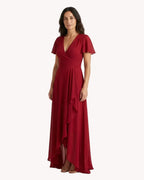 Vestido largo rojo teja con volantes, con detalles elegantes y diseño fluido para ocasiones especiales.