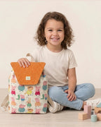 Vista lateral de una mochila infantil con estampado de animalitos y solapa naranja