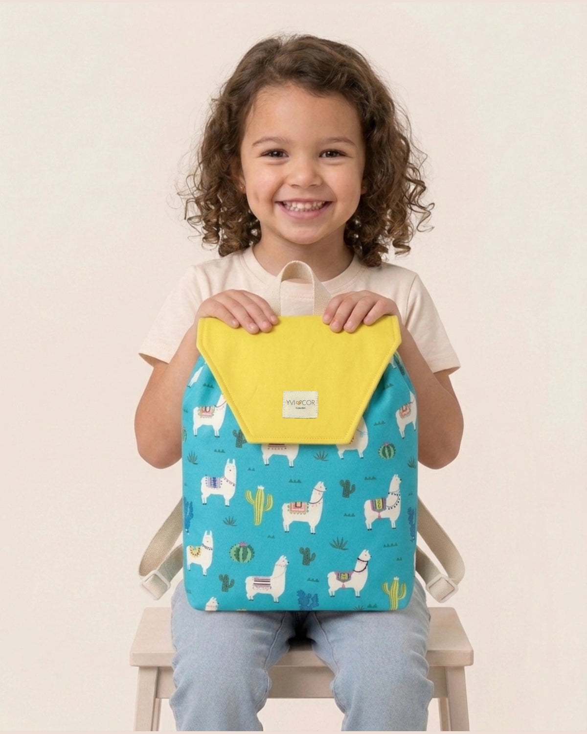 Mochila infantil turquesa con estampado de llamas, cactus y solapa amarilla