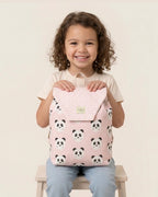 Niña sujetando una mochila infantil rosa con estampado de pandas