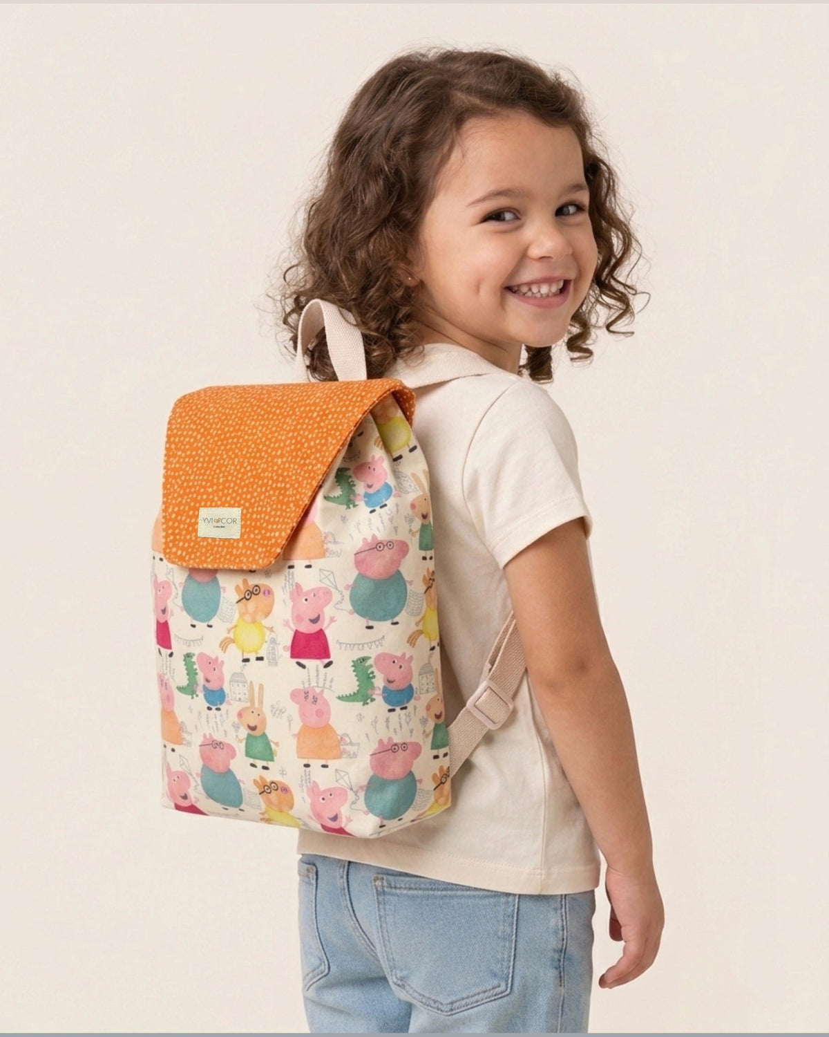 Mochila infantil con estampado de animalitos y solapa naranja