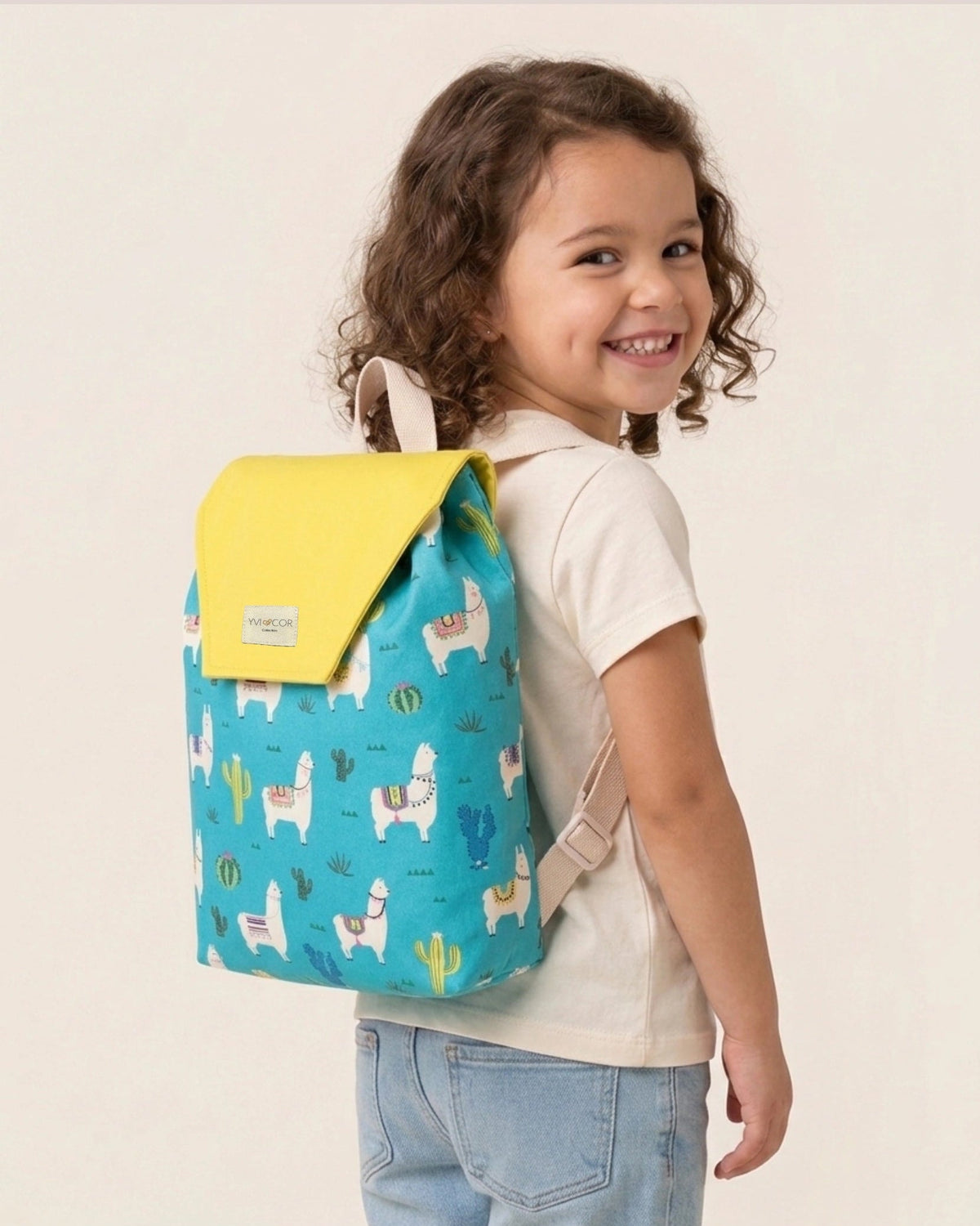 Mochila infantil turquesa con estampado de llamas y cactus y solapa amarilla