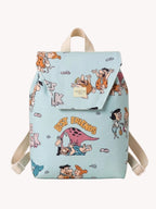 Niña llevando una mochila infantil azul claro con estampado de personajes prehistóricos