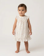 Conjunto de bebé con vestido de alas de ángel y bombacha con estampado botánico acuarela, en tonos suaves, de Yvicor Atelier de Costura.