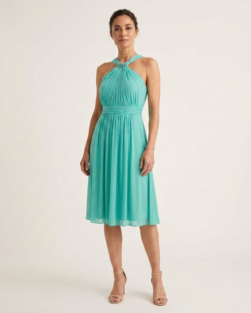 Vestido de fiesta verde esmeralda con detalles de perlas, diseñado por Invitadissimas, mostrando su elegante corte y adornos.