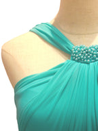 Vestido de fiesta verde esmeralda con detalles de perlas, diseñado por Invitadissimas, con corte cruzado y elegante estilo para ocasiones especiales