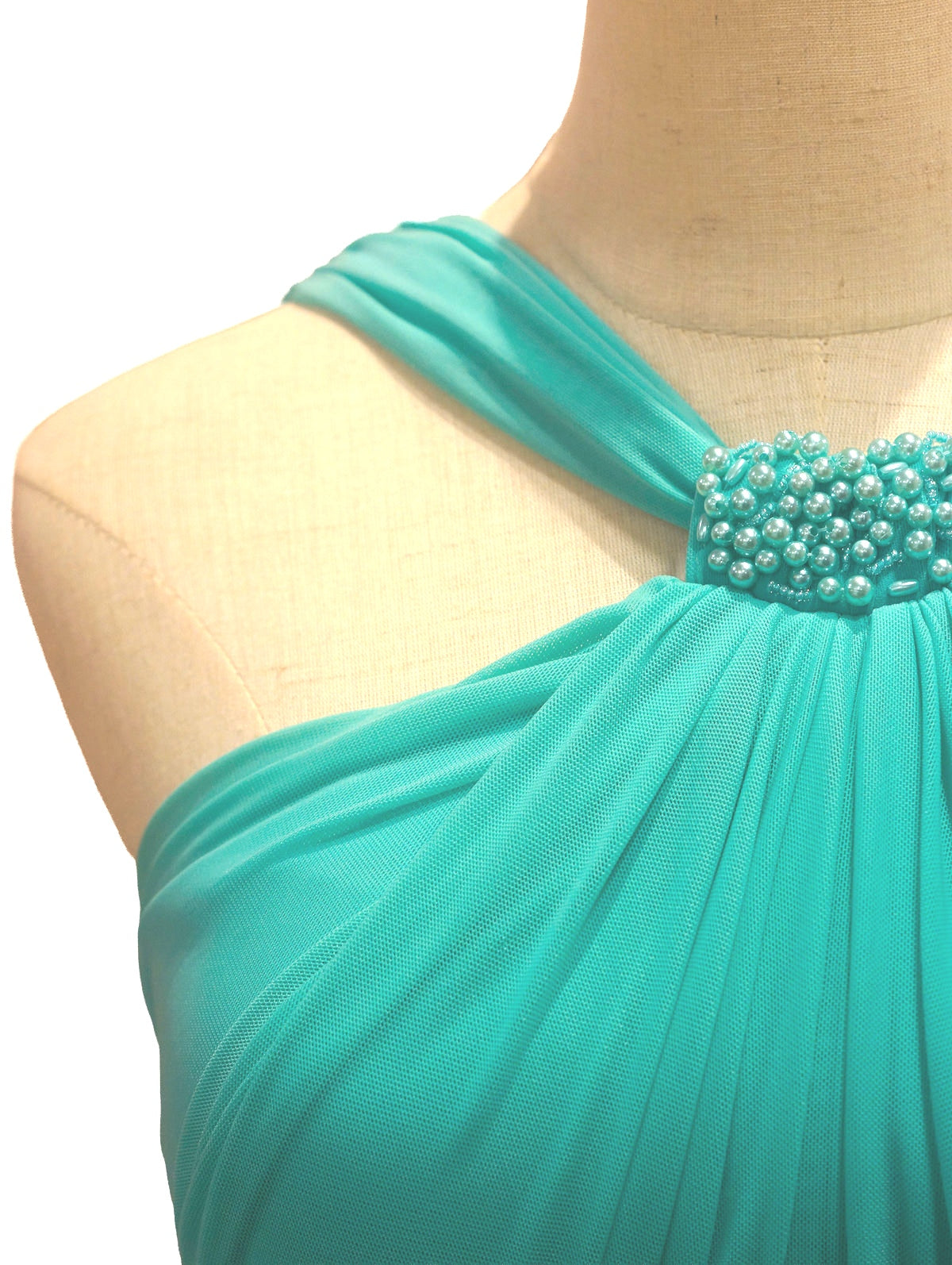 Vestido de fiesta verde esmeralda con detalles de perlas, diseñado por Invitadissimas, con corte cruzado y elegante estilo para ocasiones especiales